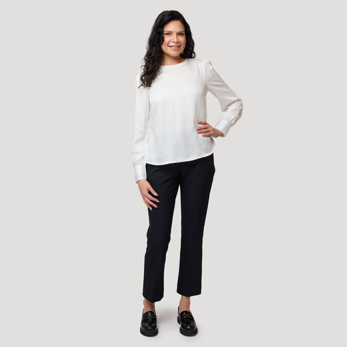 Pyöreäkauluksinen valkoinen paita tummansinisille housuille