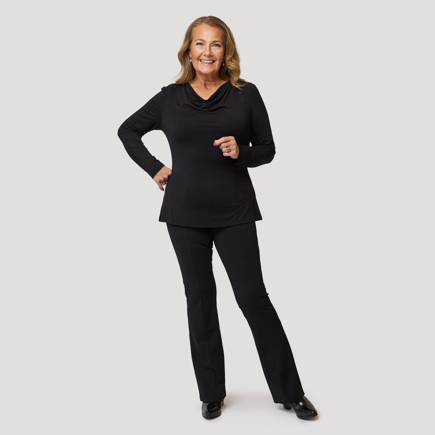 Kaunis avokauluksinen toppi mustien trikoo-housujen kanssa