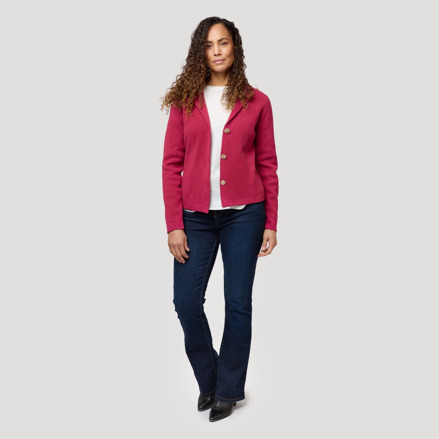 Vit blus under stickad kavaj i hallonrött