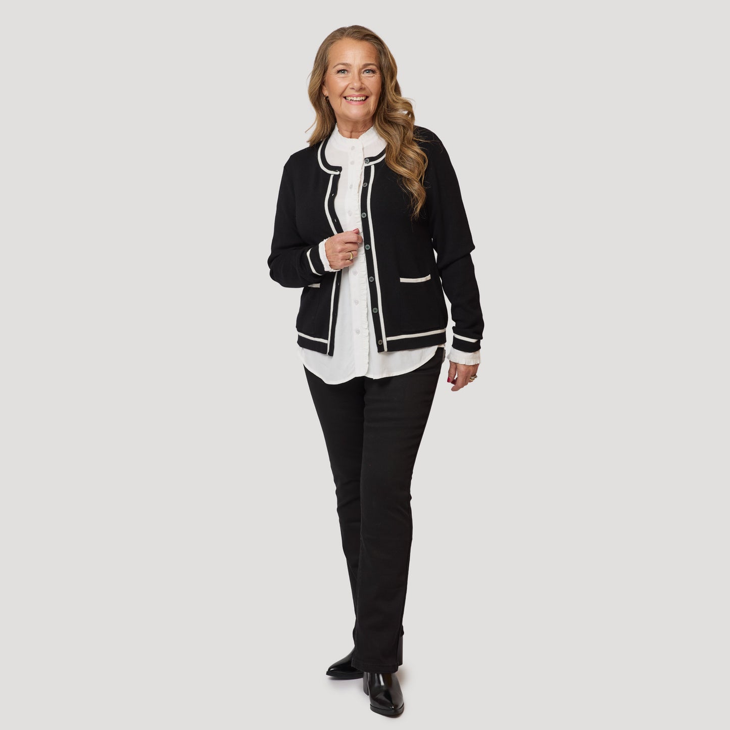 Blus med frill under svartvit kofta