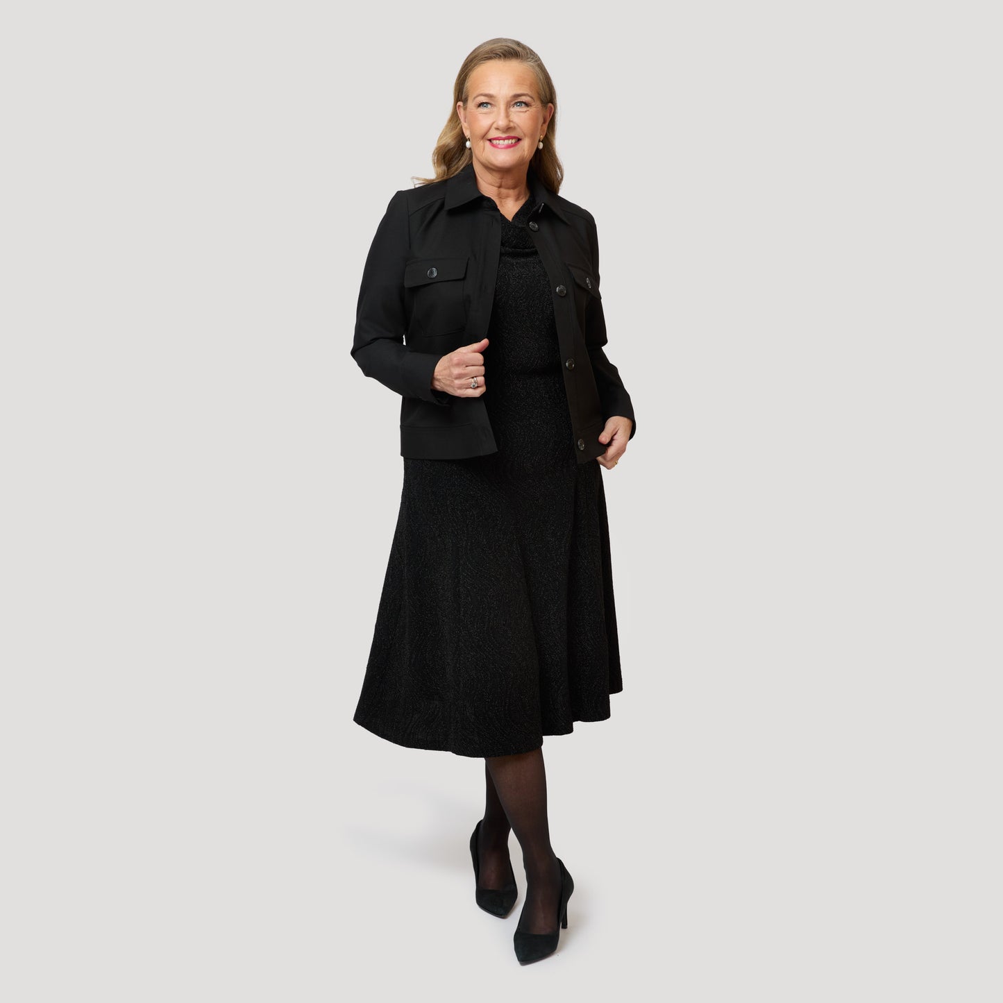 Glittrig klänning under svart jacka