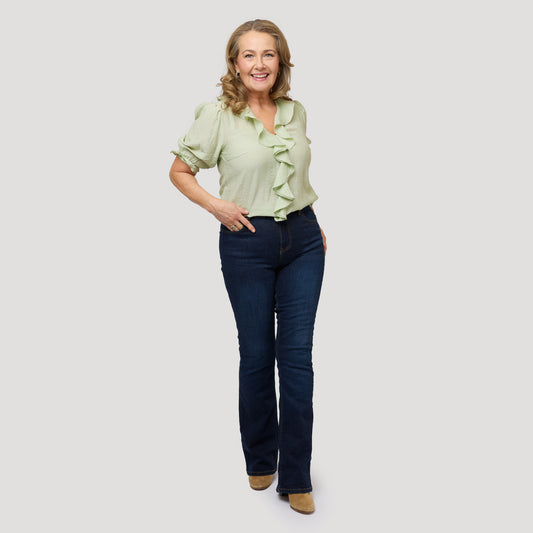 Blus med volang i ljusgrönt till mörkblå jeans