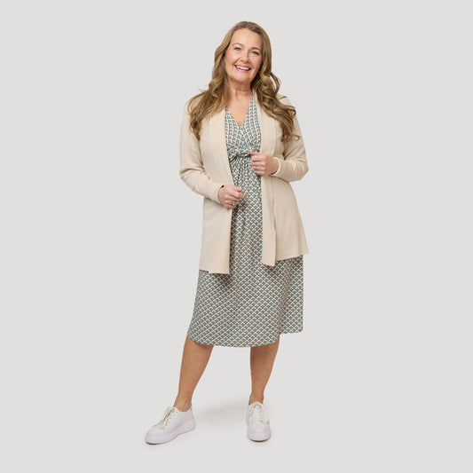 Trikåklänning under beige öppen cardigan