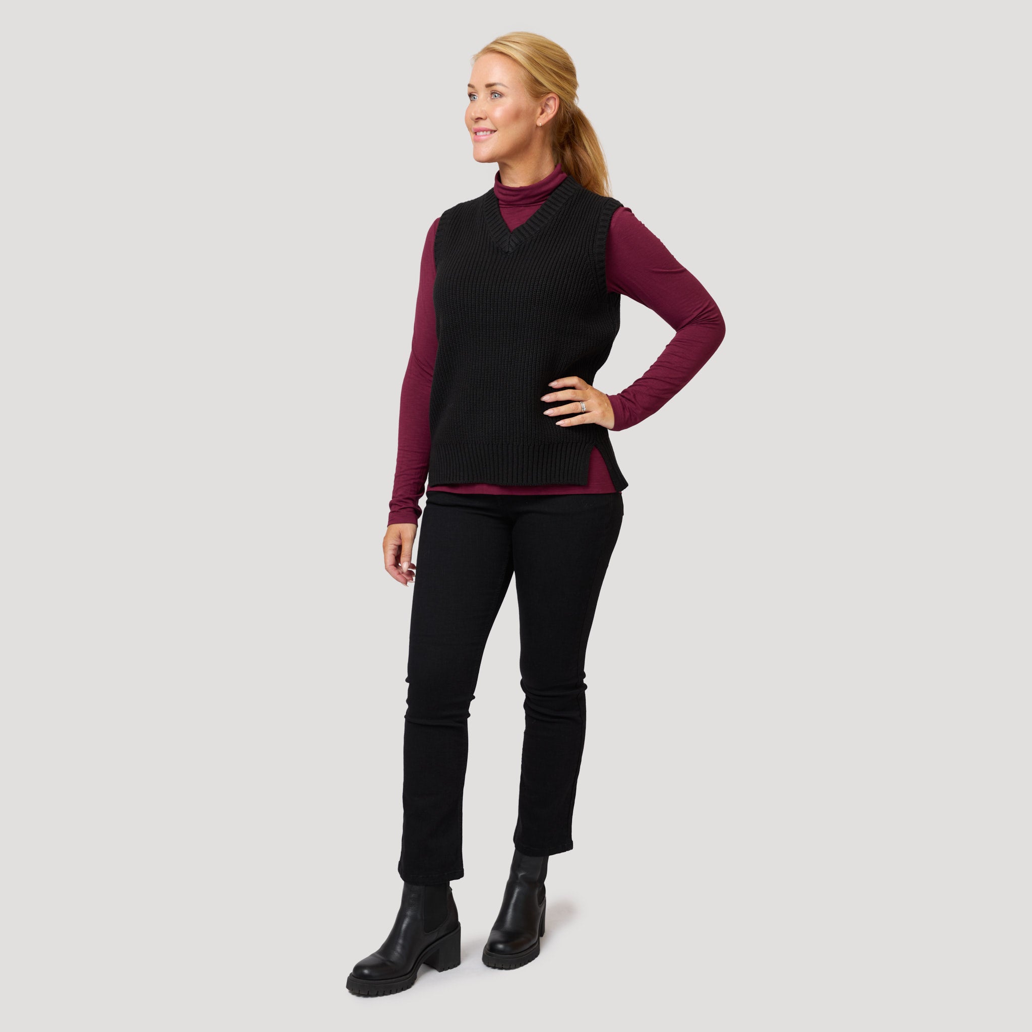 Vinröd polo under svart stickad väst