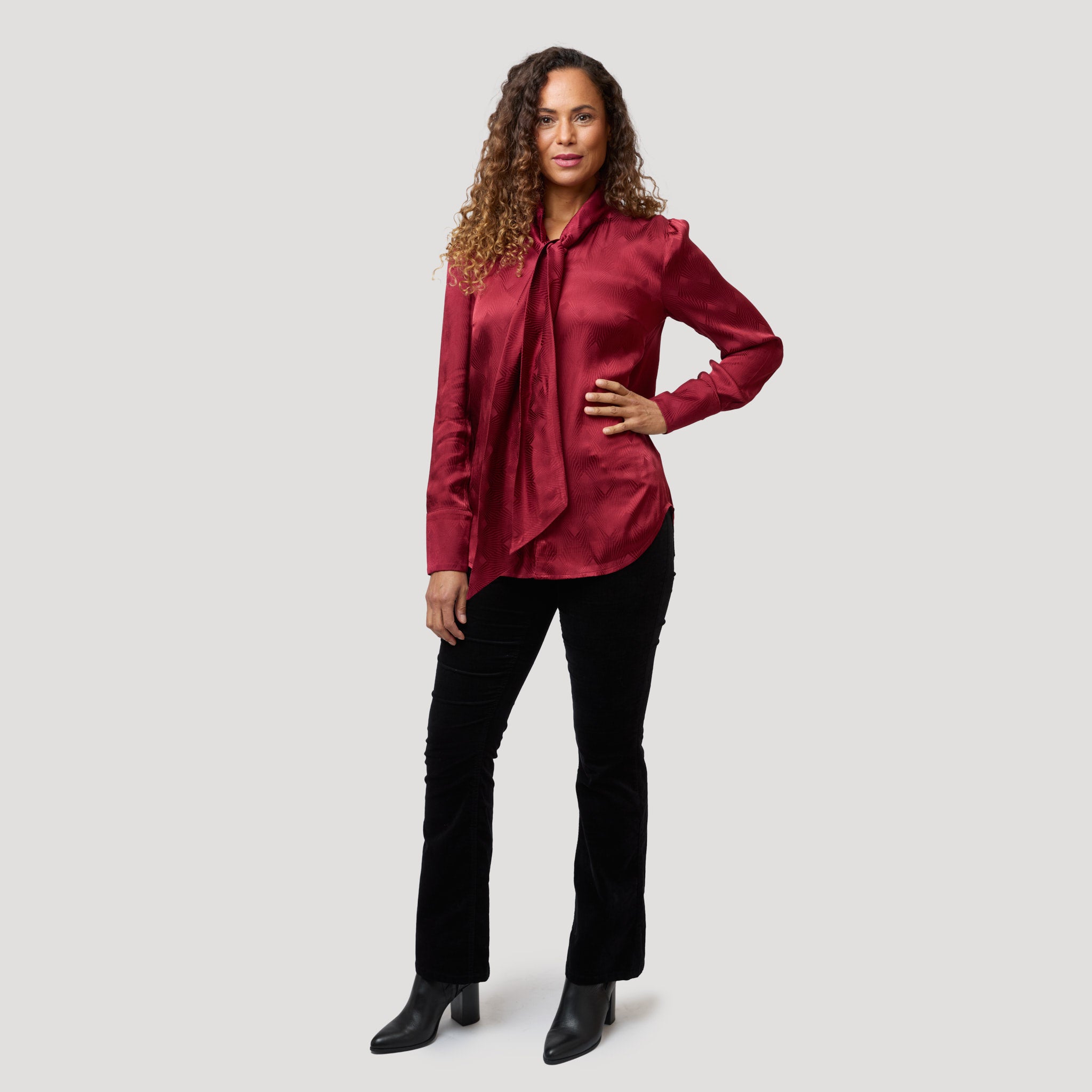 Vacker röd knytblus till sammetsbyxor i svart